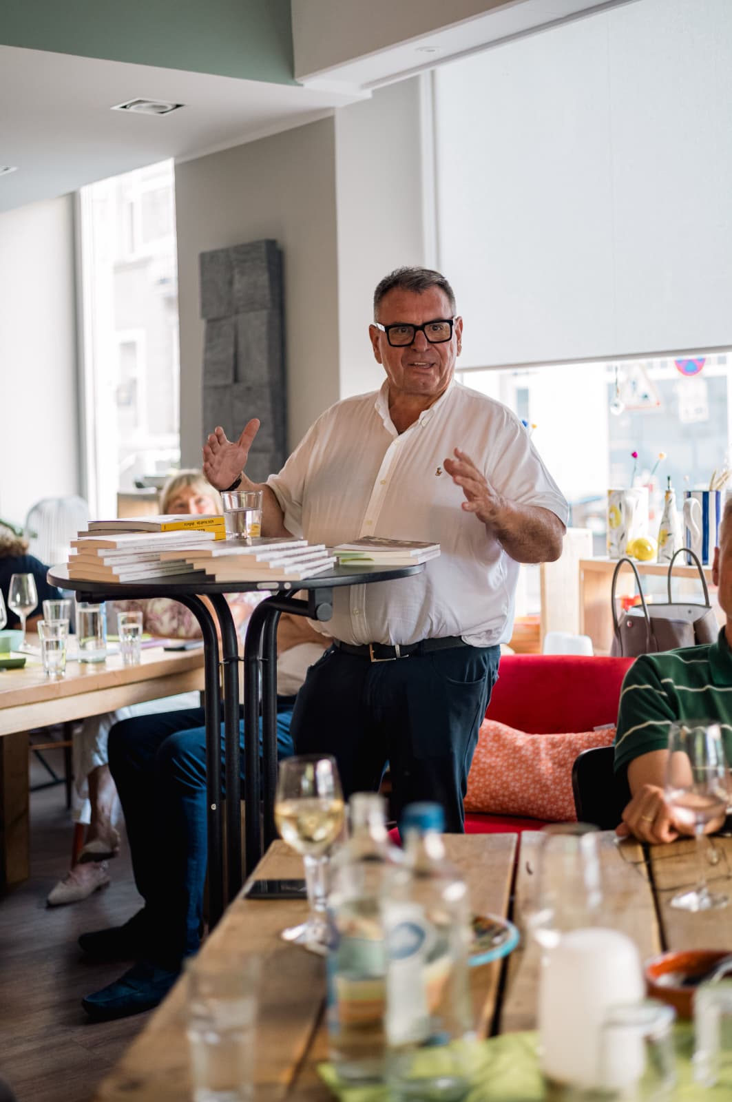 Michael Johannes bei einer Lesung mit Büchern auf dem Tisch